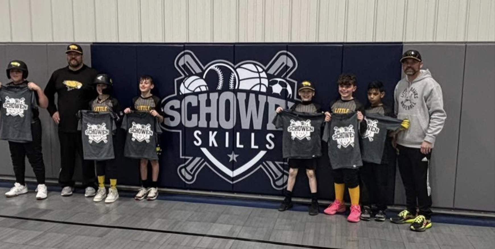 Team photo in front of the Schowen Skills logo wall